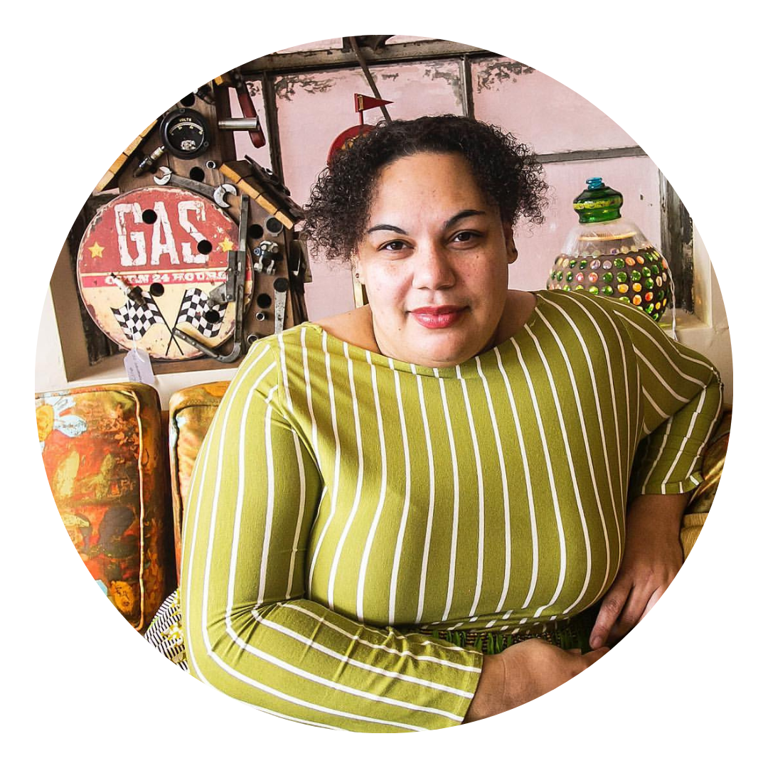 Rev. Carla Christopher posing headshot in front of antique items and window frame